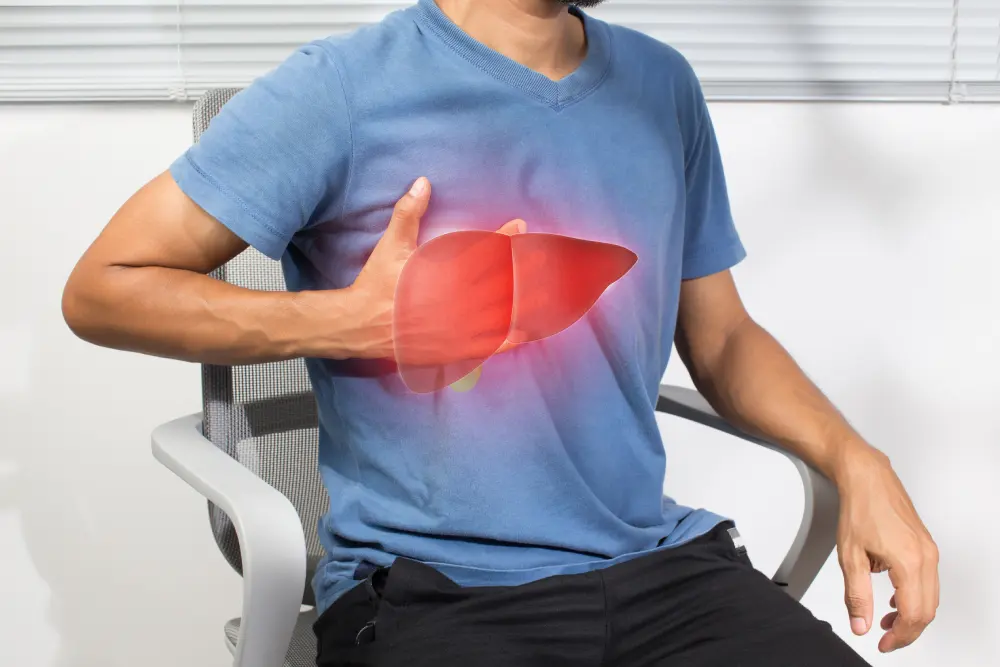 Man holding upper right abdomen with glowing liver illustration.